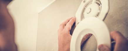 Caucasian Men Installing Electric Air Vent in the Apartment Bathroom. Closeup Photo. Air Ventilation and Climate Control Theme.