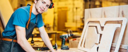 Successful carpenter looking at camera in workshop