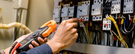 Electrician engineer work  tester measuring  voltage and current of power electric line in electical cabinet control.