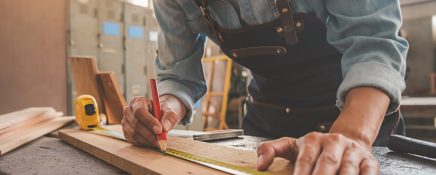 Carpenter working with equipment on wooden table in carpentry shop. woman works in a carpentry shop.