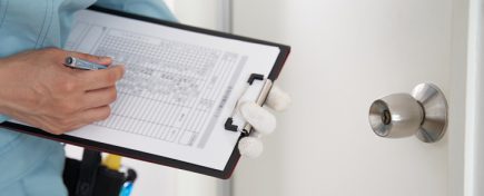 A Japanese male worker checks the locks on a house