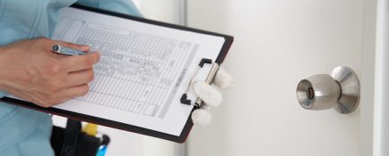 A Japanese male worker checks the locks on a house