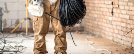 Electrician with tools, working on a construction site. Repair and handyman concept.