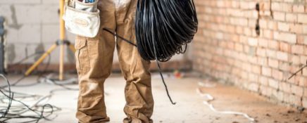 Electrician with tools, working on a construction site. Repair and handyman concept.