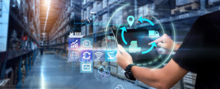 A logistics manager using modern technology at a warehouse after logistics management courses