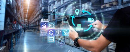 A logistics manager using modern technology at a warehouse after logistics management courses