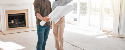 Two people in their home reviewing project blueprints