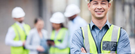 A construction worker smiles at the camera while working with his colleagues after Home Renovation Training
