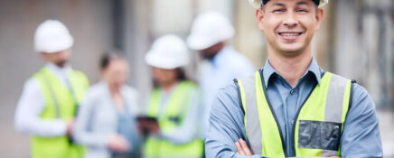 A construction worker smiles at the camera while working with his colleagues after Home Renovation Training