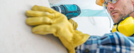 A male drywall installer in a building after home renovation training.