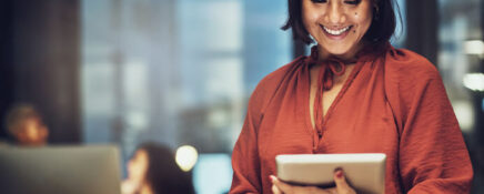 A female supply chain and logistics professional holding a tablet in an office after supply chain and logistics training