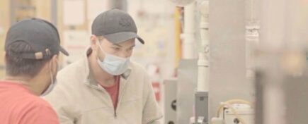 A pair of HVAC technicians troubleshooting an appliance after HVAC technician training